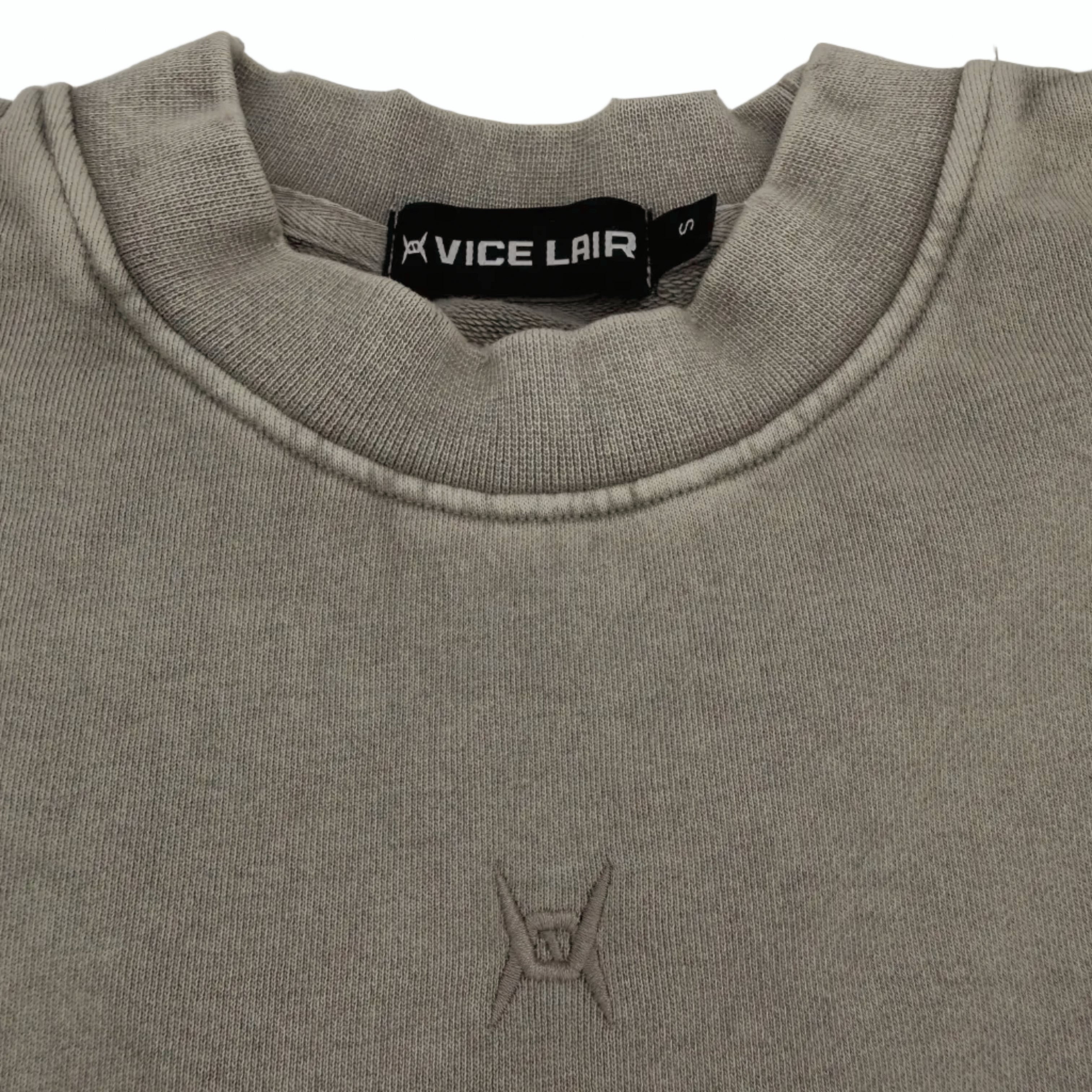 Grey crewneck sweater collar with embroidered logo on white surface